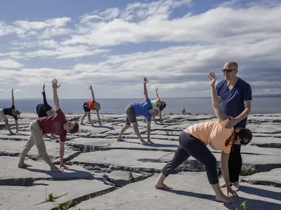 Adjusting yoga pose in outdoor yoga class | Wellness Retreat Ireland