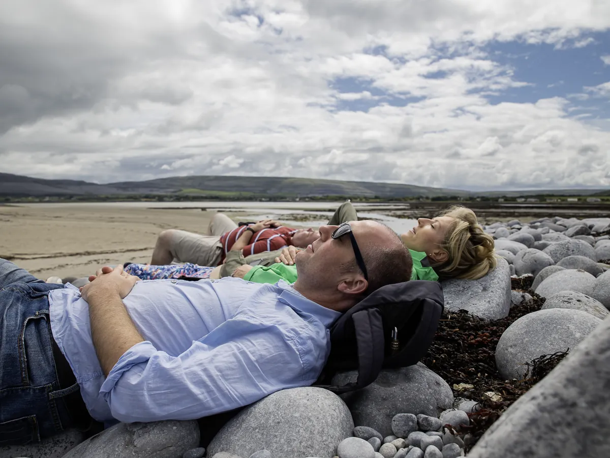 Group lying on large round rocks beside the beach 1 |
