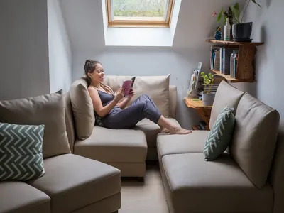 a woman sitting on a couch reading a book